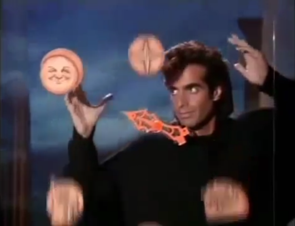 Das Bild zeigt einen Filmstill von "Sweaty Transition" mit blauen, beigen und schwarzen Farbtönen. Es zeigt einen berühmten Zauberkünstler David Copperfield der vor einer Glasscheibe, mit erhobenen Armen steht. Auf der Glasscheibe sind runde, beige Symbole und ein roter Pfeil der zu dem Symbol des Mondes zeigt. Seine Augen schauen ebenfalls zum Mond. Hinter den Zauberkünstler ist ein blauer Himmel.
